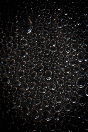 Water drops an black plastic surface の写真素材