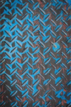 Close up of real worn diamond plate material with chipped paint  