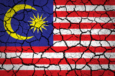 Malaysia flag painted on cracked ground 