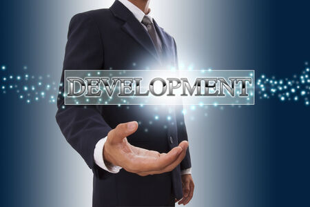 Businessman hand showing development button on virtual screens の写真素材