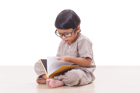 Cute boy is reading a book while wearing glasses の写真素材