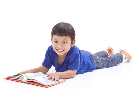 Little boy reading book with lying on the floor