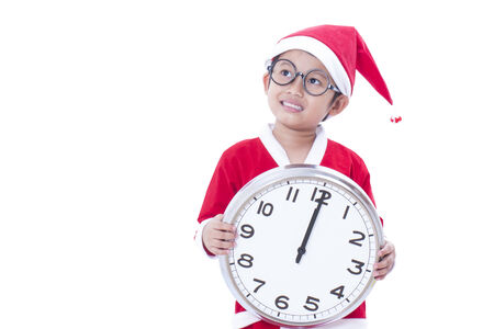 Little boy holding a big clock at christmasの写真素材
