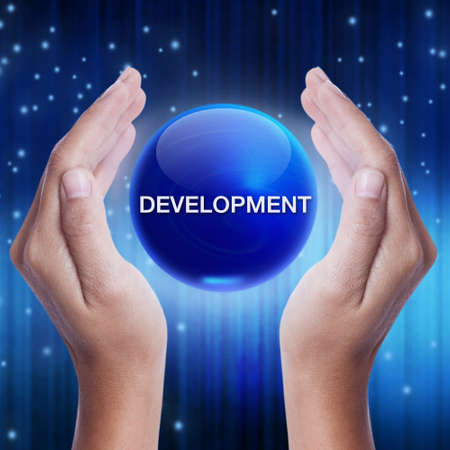 Hand showing blue crystal ball with development word. business conceptの写真素材