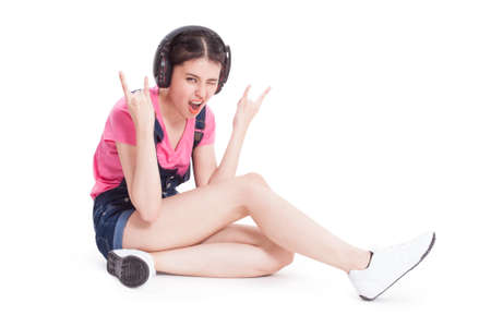 Young woman with headphones listening music on white backgroundの写真素材