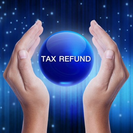 Hand showing blue crystal ball with tax refund sign. business conceptの写真素材