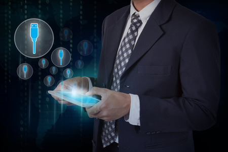 Businessman hand touch screen flash drive icons on a tablet.の写真素材