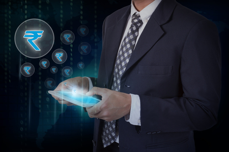 Businessman hand touch screen rupee sign icons on a tablet.の写真素材