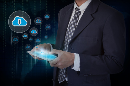 Businessman hand touch screen download from cloud icons on a tablet.の写真素材
