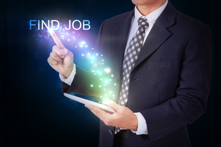 Businessman holding tablet with pressing find job. internet and networking conceptの写真素材
