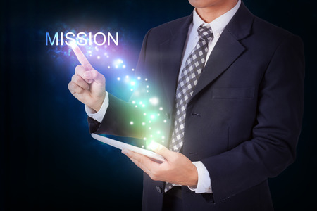 Businessman holding tablet with pressing mission. internet and networking conceptの写真素材