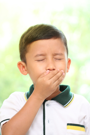 A Little boy coughing on green backgroundの写真素材