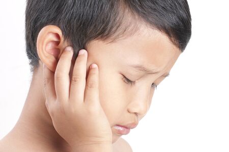 Tinnitus. Closeup up side profile sick boy having ear pain touching his painful head.