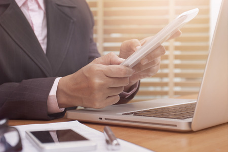 Business woman using tablet computer on desk at workの写真素材