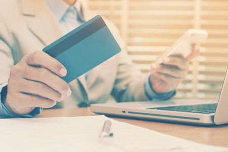 Business woman hands holding credit card and using mobile smart phone for online shopping.の写真素材