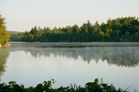 early morning mist on lake in Quebecの写真素材