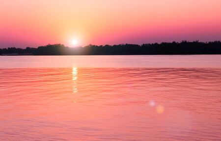 The peaceful river, with only a few waves in the sunset, is an atmosphere that feels lonely.の写真素材