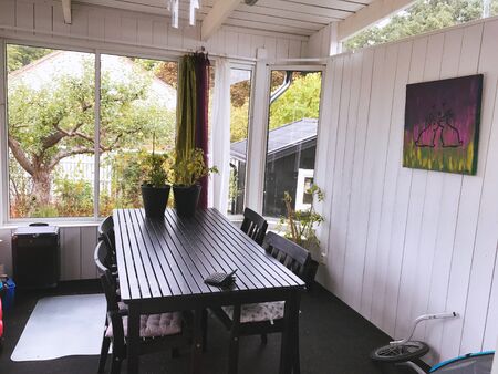 The white wall and black dining table with plant pots on top, with the background in front of the house.の写真素材