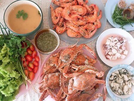 Dinner is seafood. There are shrimp, crab, squid, clam, tomato, salad and soup.の写真素材