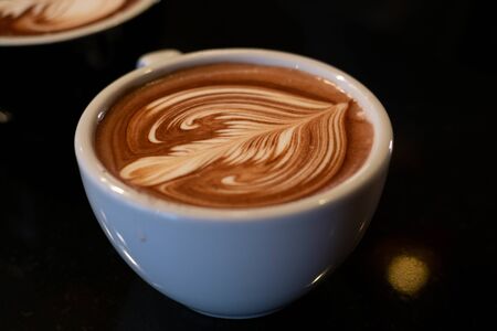 latte art, tulips on a white glass, black background