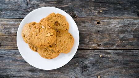Cashew cookies in a white plate on a high angle wooden floorの写真素材