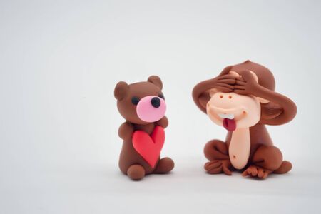 Monkey doll close eyes and bear doll holding heart, for valentine's day, isolatedの写真素材