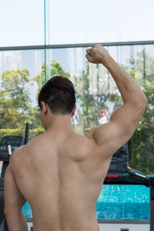 handsome man show muscle body in the gym or fitness center, Health conceptの写真素材