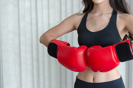 woman in black sportswear and red boxing gloves ready to fighting and copy spaceの写真素材
