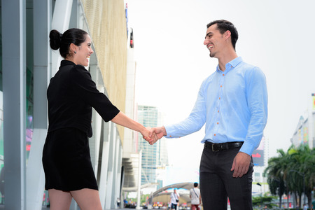 businessman and businesswoman shaking hands smile for success agreement at the outdoor placeの写真素材