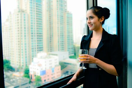 smile of beautiful business woman at the window with champagne, business successful concept, vintage styleの写真素材
