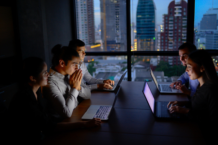 business team working with computer overtime at night and low lightの写真素材