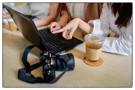 three business woman work and meeting with laptop and camera on the tableの写真素材