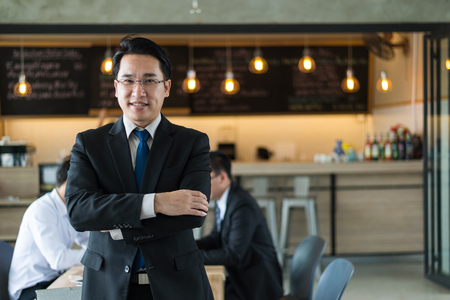 Asian businessman wear black suit standing and looking to camera. business successful conceptの写真素材