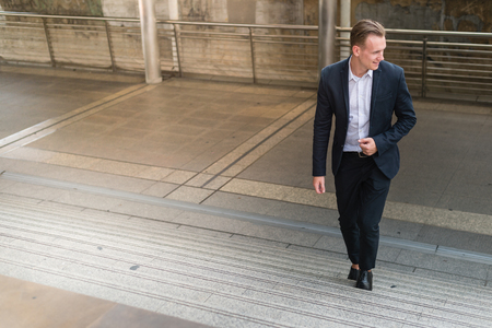 businessman wear black suit walking stepping up stair in modern city, business grow up and success concept, Ambitions conceptの写真素材