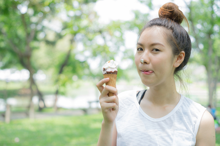 woman sloppy from eating ice cream cone. she happy and smile.の写真素材