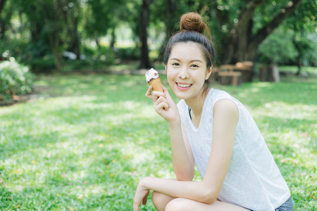 woman sloppy from eating ice cream cone. she happy and smile.の写真素材