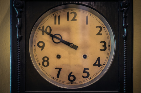 old yellow vintage clock on wooden background