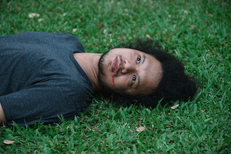 Men dead on the grass and bleed from the mouth.