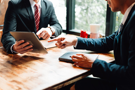 two businessman sitting and looking at tablet, they are meeting about business plan, marketing and financial in the future. concept of business success, business meeting.