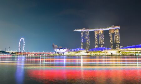 singapore, singapore - April 12, 2019: panorama background of Marina Bay, Singapore City at night with long exposure light of boat.のeditorial素材