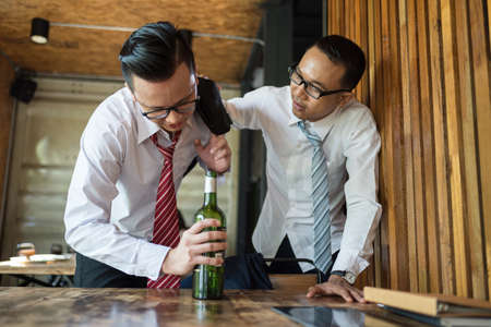 two businessman is drunk and laughing after drinking hard in restaurant to celebrate the success of work. concept of winner and business successfulの写真素材