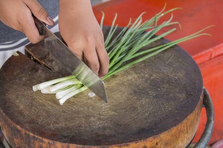 Use a knife to cut vegetables for cooking.の写真素材