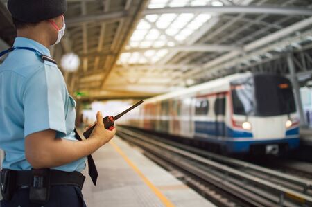 Security guards on the Bangkok BTS Thailand station stand for security checks on 09/03/2020の写真素材