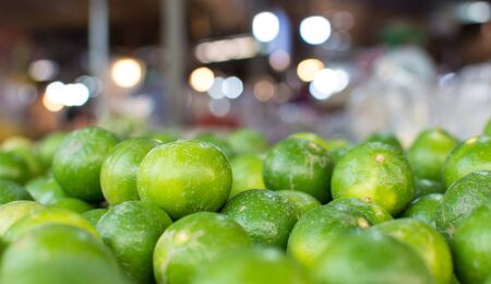 Many green lemons at the marketの写真素材