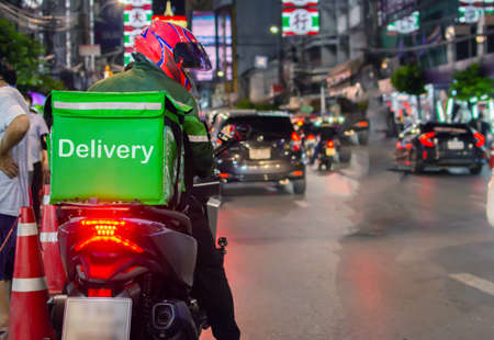 Food delivery drivers are driving to deliver products to customers who order online at night.