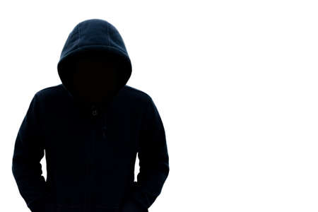 A man with a hood does not see his face. Danger in the dark On a white background With a blank space on the right for text or designの写真素材