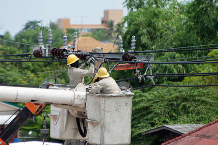 Electricity workers stand on the cable car for maintenance, maintenance of the high voltage line...