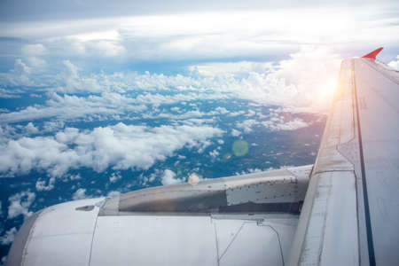 The view from the plane window The morning sun passed through the wings of the bright sky and the clouds.の写真素材