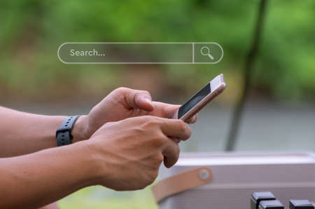 Smartphone in hand to find information and what interests them. Internet search conceptの写真素材