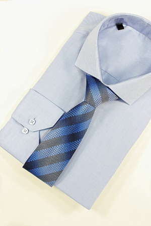 Blue shirt and striped tie on a white backgroundの写真素材